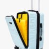 Light blue hard shell laptop trolley bag with a geometric pattern and an open front compartment revealing a vibrant yellow interior.
